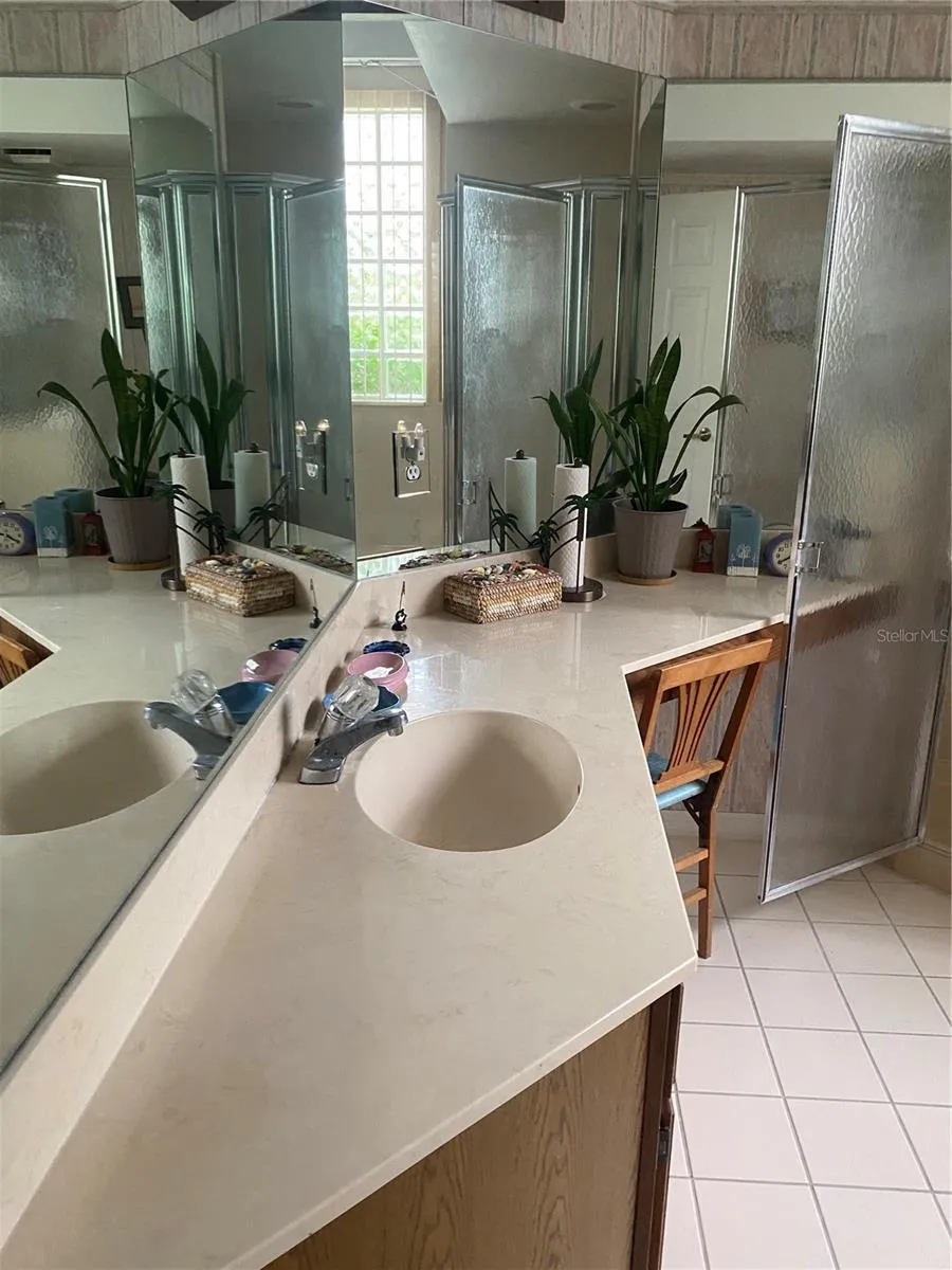 Primary bathroom upgrade countertops, vanity area with chair sitting area. Walk in showder with tub separate area.