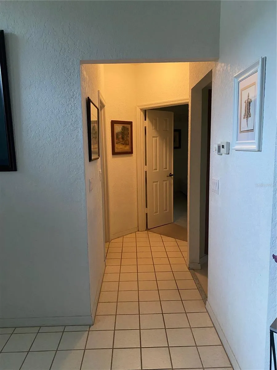 Hallway to the primary bedroom. Tiles flooring area.