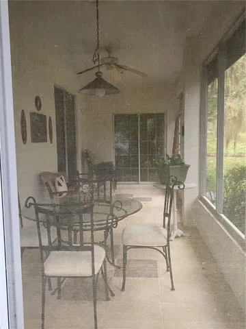 Screened in lanai with ceiling fan and lighting, tiles flooring long access from the kitchen and living area.