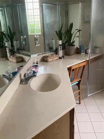 Primary bathroom with drawers and sitting area large mirror