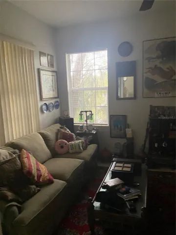 Den room with high ceiling, ceiling fan with big windows
