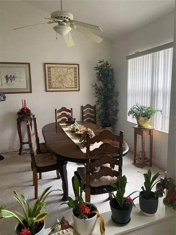 Formal dining room area. Large window, ceiling fan with lights, high ceiling, spacious area.