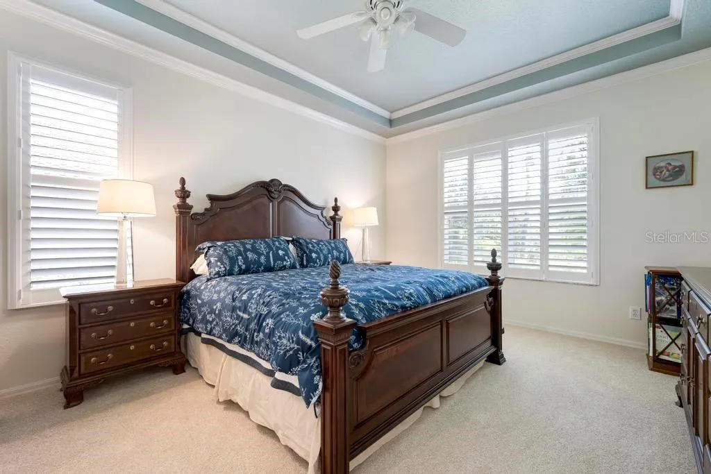 Primary Bedroom with tray ceiling and plantation shutters