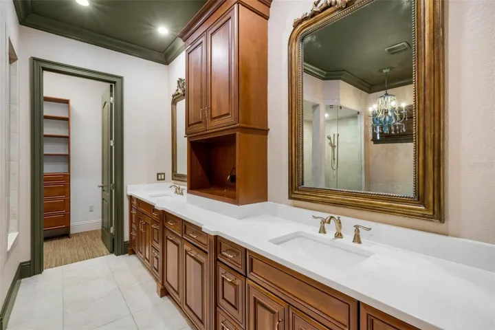 The ensuite bathroom features a long-split vanity with central tower for added storage.