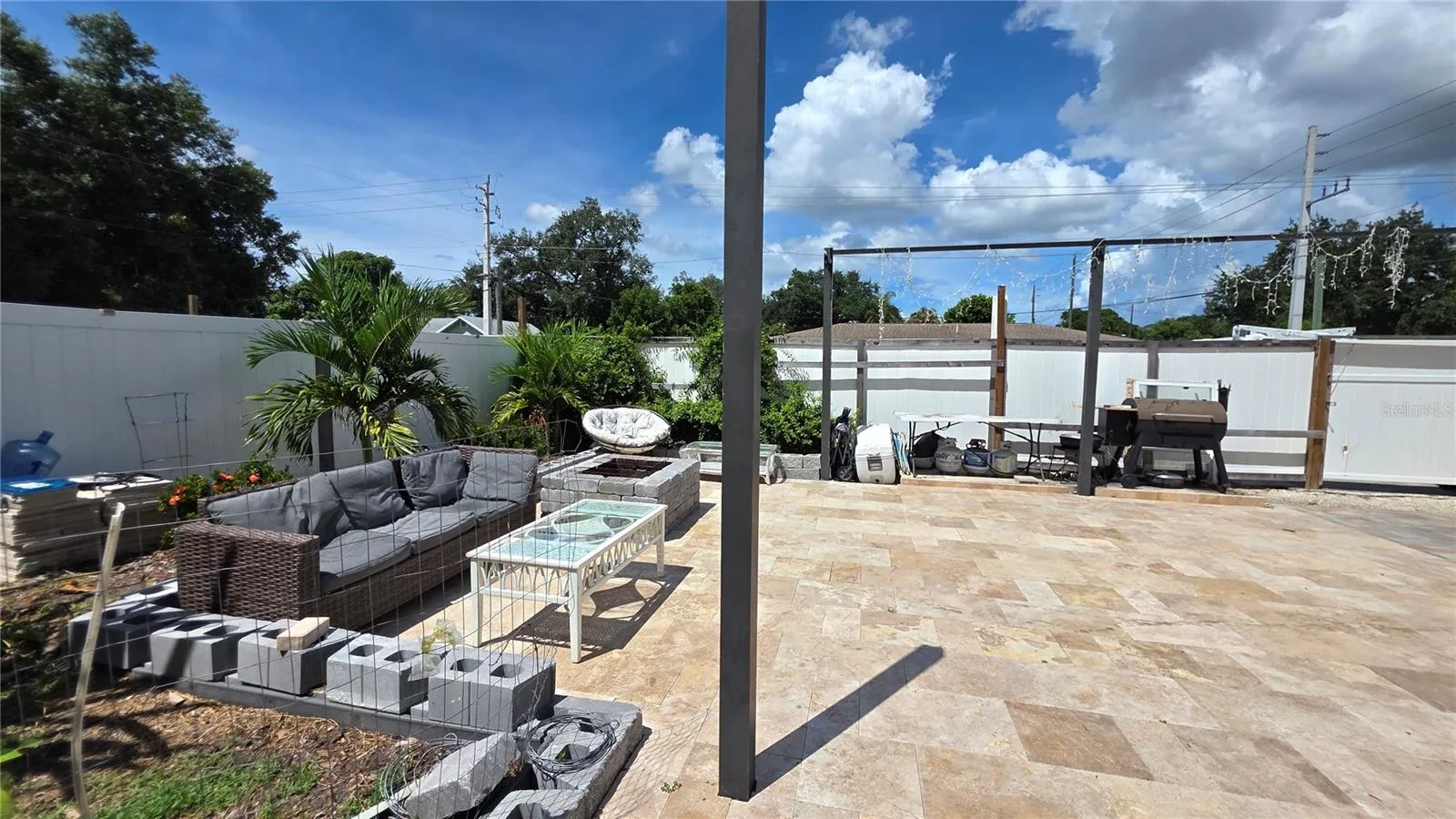 Pavered/Tiled back patio area with vinyl fence partition