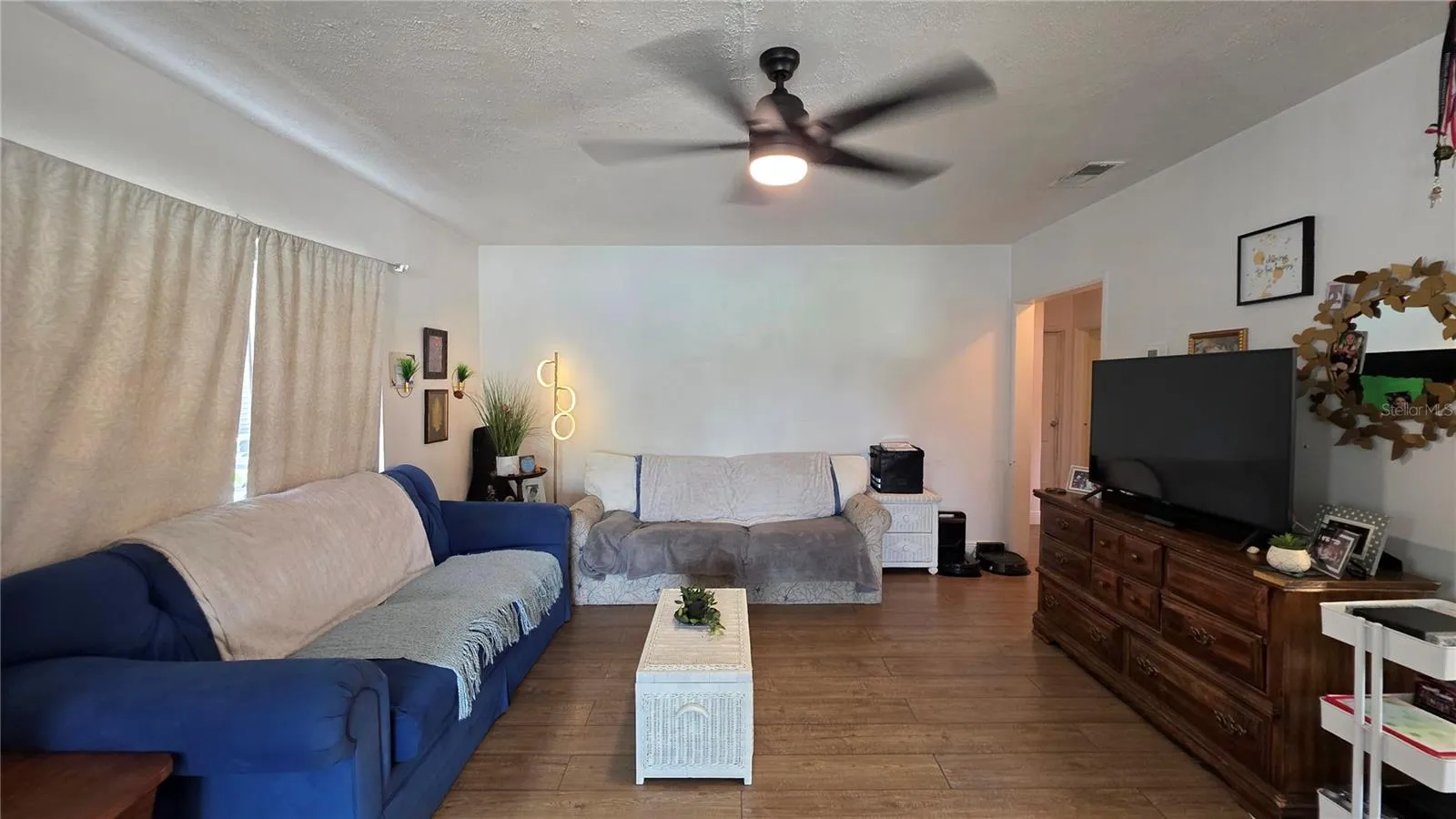 Living Room with Ceiling Fan, Laminate Flooring, and Window overlooking Front Yard