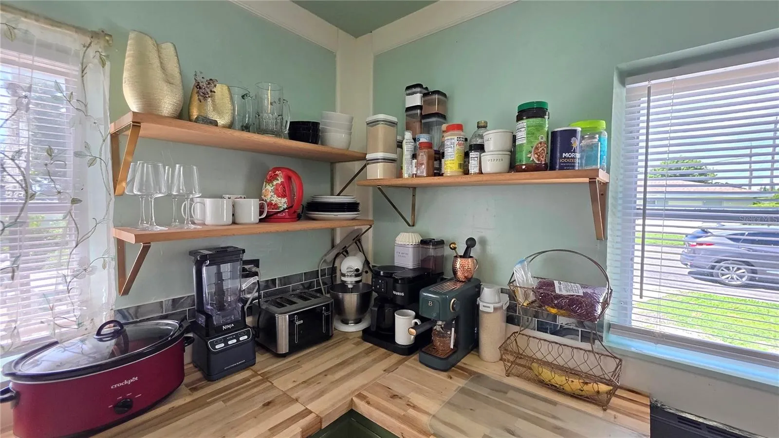 Corner View of Kitchen Counter, Shelving, and Windows