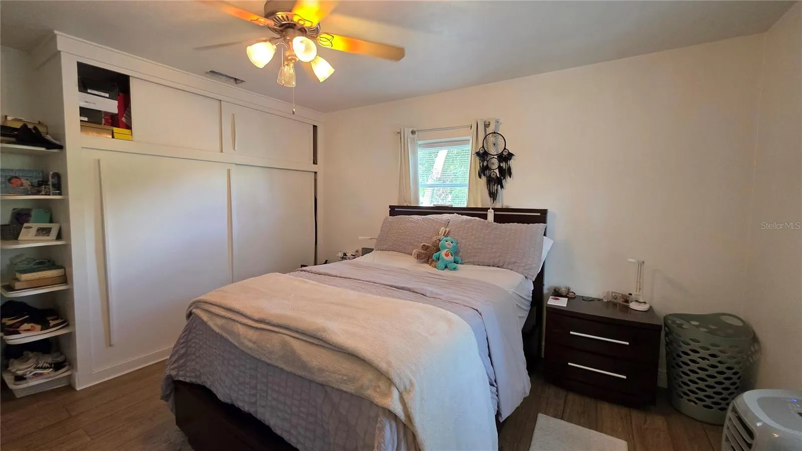Primary Bedroom, Decorative Shelving, Ceiling Fan, Laminate Flooring, Window overlooking Front Yard