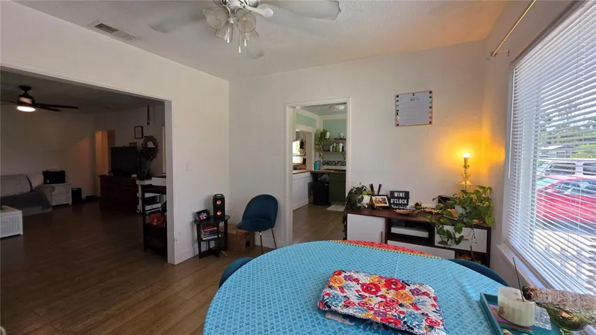 Dining/Flex Room Adjacent to Livingf Room, with Ceiling Fan, Laminate Flooring, and Windows overlooking Side Yard