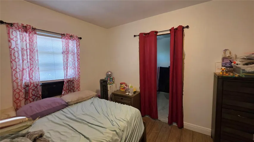Bedroom #2 with Laminate Flooring and Window to Side Yard View (Entry to En-Suite Bathroom Addition - will need to be removed)