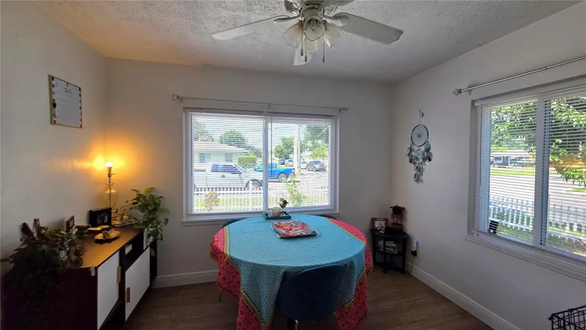 Dining/Flex Room with Ceiling Fan, Laminate Flooring, and Windows overlooking Side Yard and Front Yard