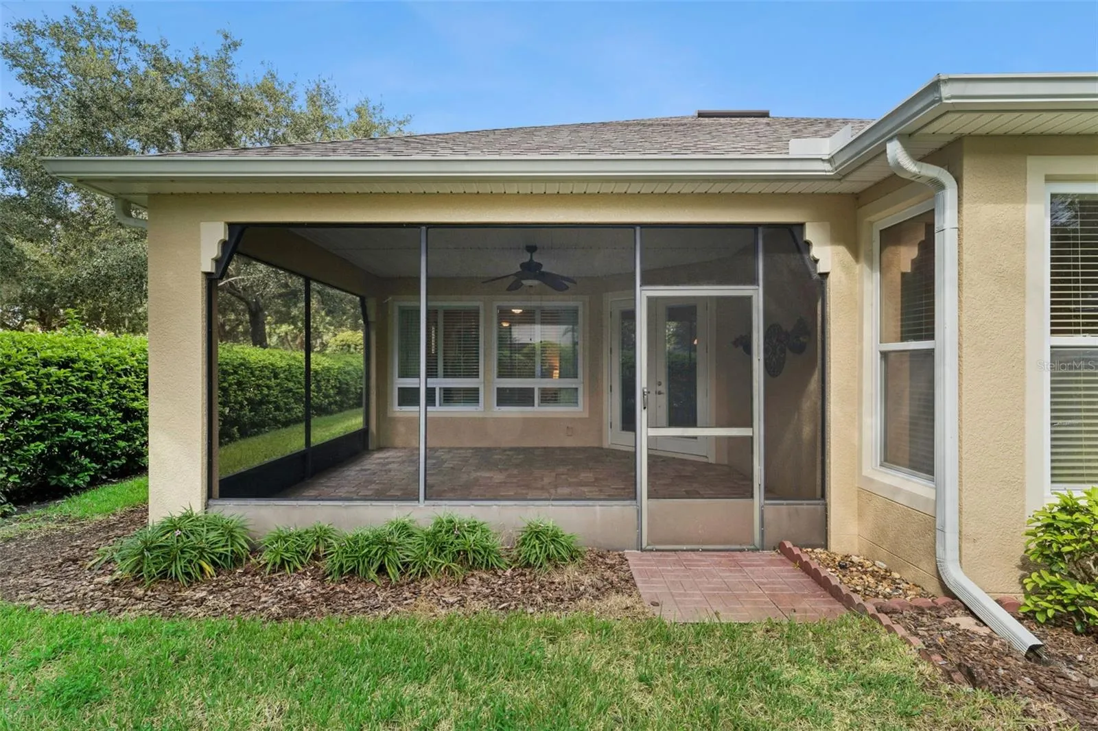 View of the screen enclosed covered patio w/ gutter downspouts around perimeter