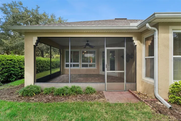 View of the screen enclosed covered patio w/ gutter downspouts around perimeter