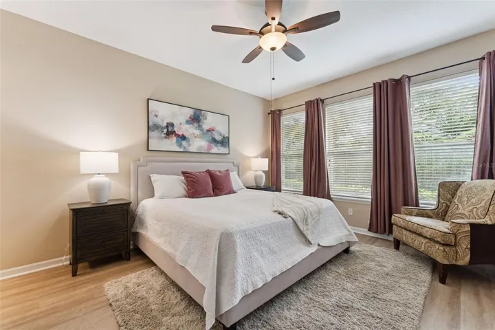 12'6" x 15' Primary Bedroom w/ luxury vinyl floor & a ceiling fan