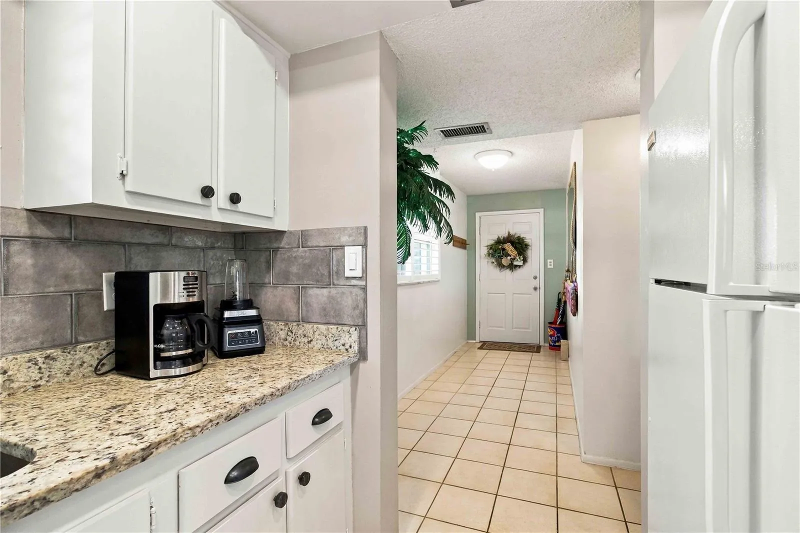 Kitchen featuring white appliances and granite counters