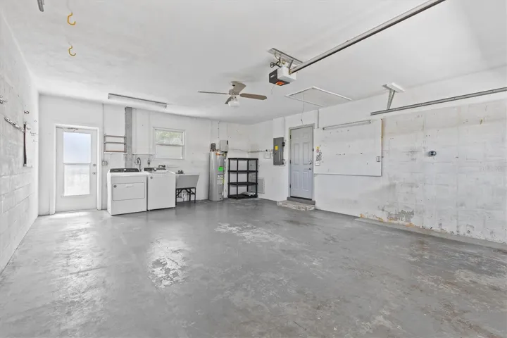 Full sized washer and dryer with dry sink in the garage.