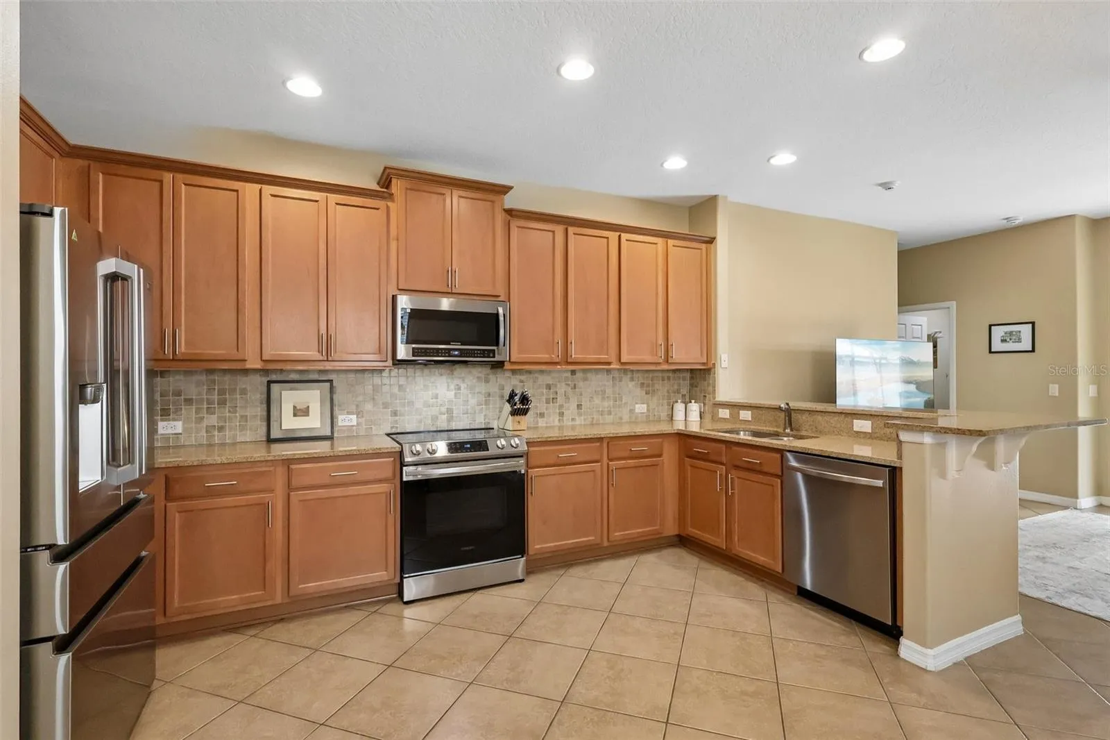 Tile backsplash, stainless steel appliances and open to the family room