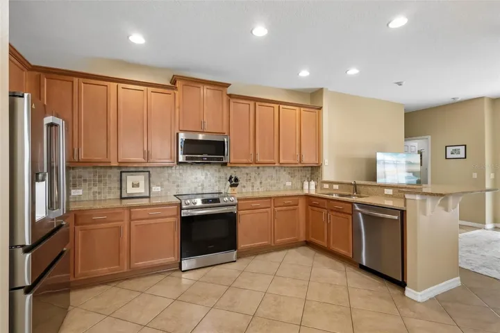 Tile backsplash, stainless steel appliances and open to the family room