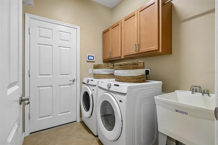 Interior laundry room with a utility sink &amp; extra cabinets