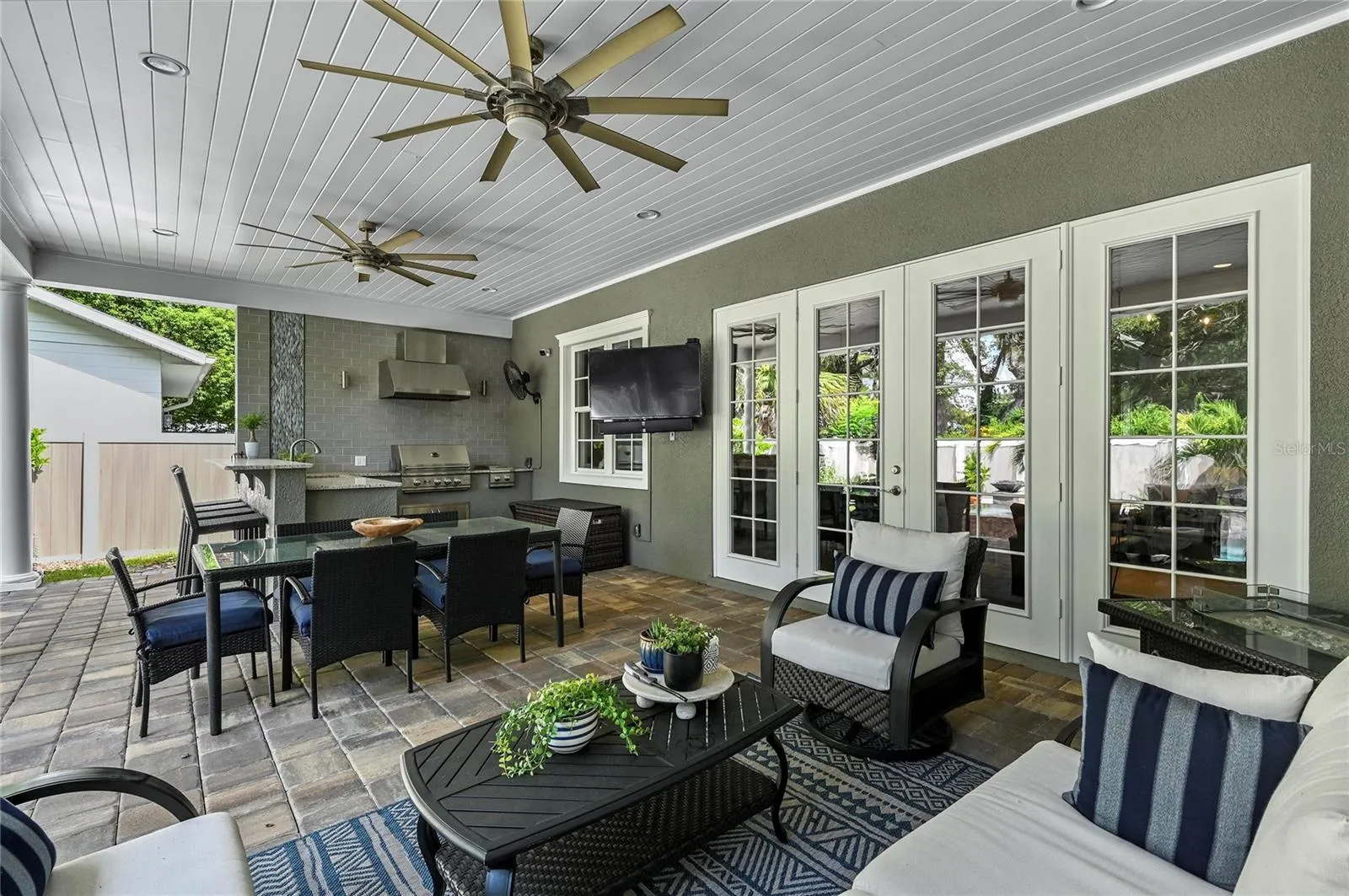 The back patio is a stunning living area providing room for seating, dining, cooking and entertaining, with the heavenly and lush landscape being reflected on all sides.