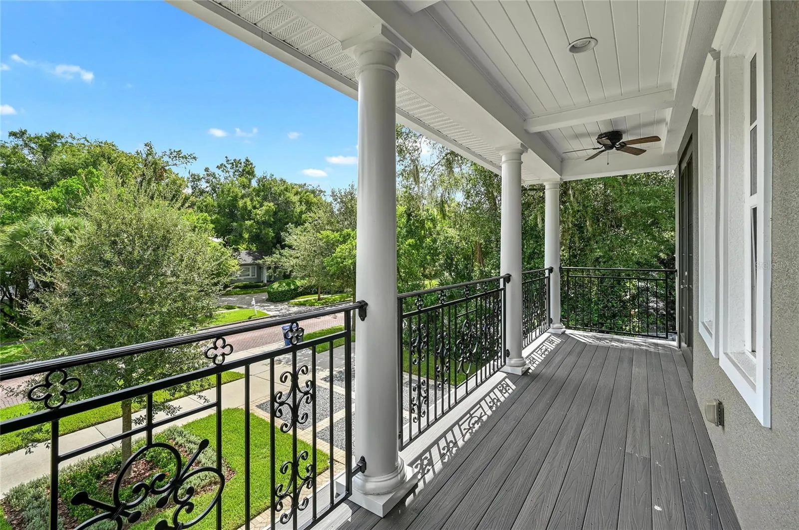 The upper porch is a taste of Southern charm, complete with fans and iron-rail detailing.