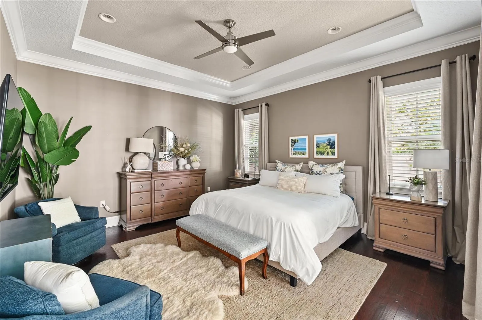 The spacious primary bedroom echos the high ceilings and finishes in the main living areas.