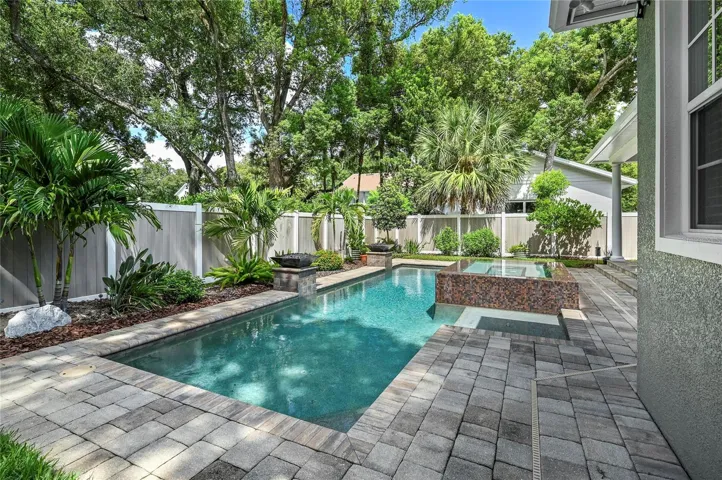 The back of the home looks out to beautiful skies and a towering tree canopy.