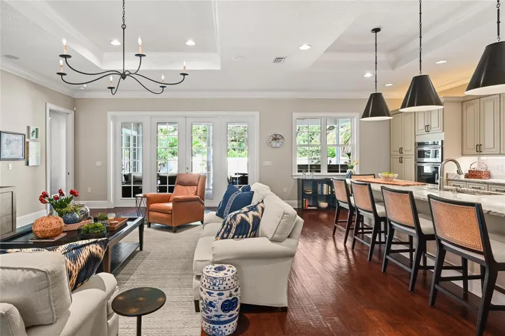 The interior living area flows seamlessly to the backyard oasis, with views through expansive French doors.