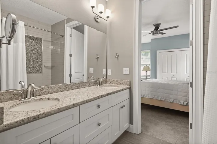 The bathroom features double sinks and a linen storage closet.