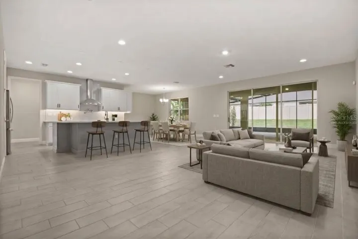 Open floor plan with triple slider leading to back Lanai virtually staged