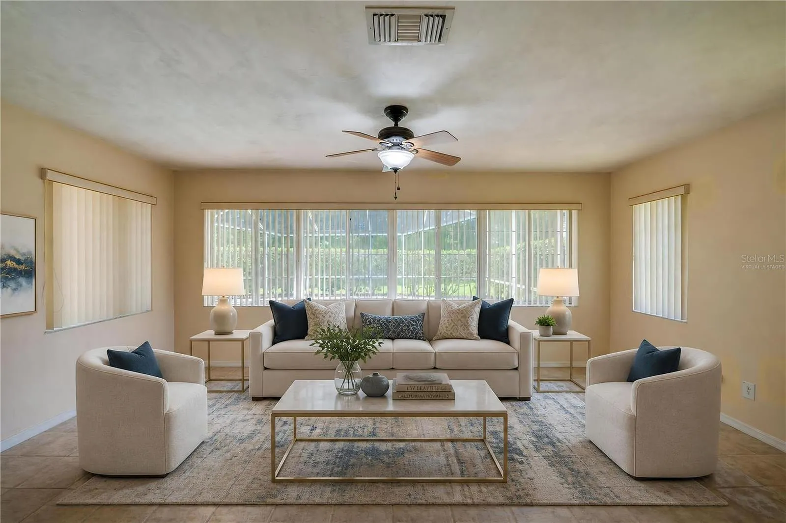 Virtually Staged - Bright enclosed sunroom equipped with light beige tile flooring, a ceiling fan, and wide windows fitted with vertical blinds for controlled light.