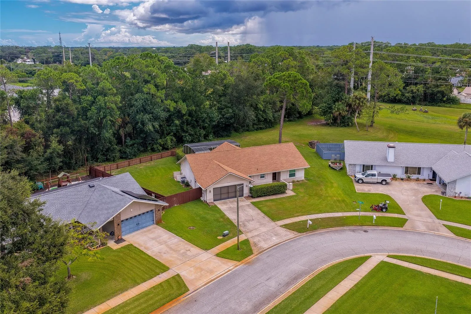 Elevated neighborhood view displaying the property's location along a quiet residential street bordered by mature trees.
