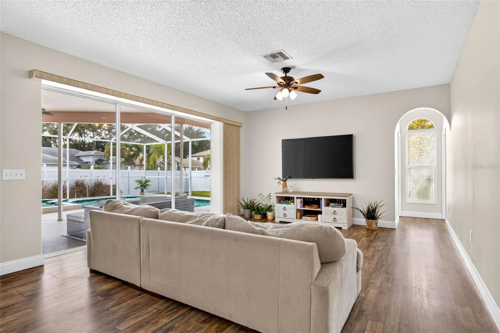 Large family room adjacent to kitchen with views of screened pool lanai