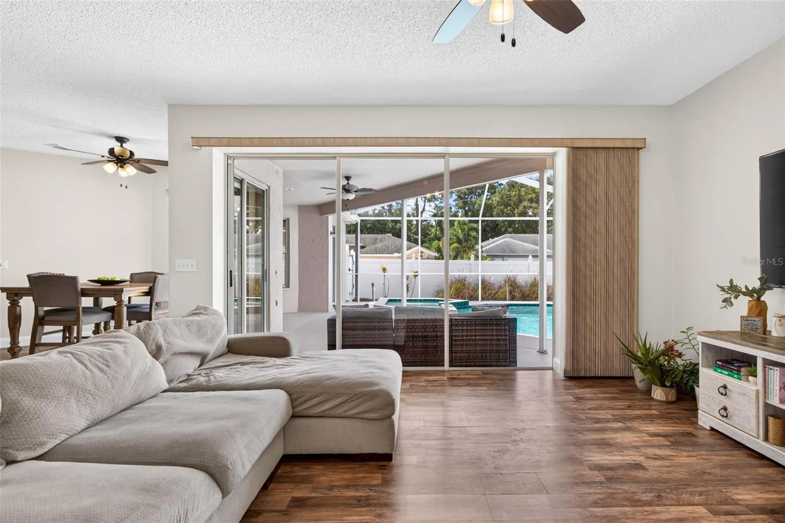 Large family room adjacent to kitchen with views of screened pool lanai