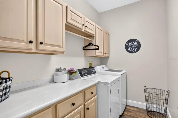 Interior laundry room with ample cabinets and counters