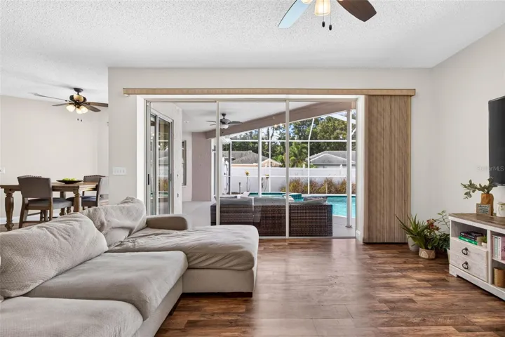 Large family room adjacent to kitchen with views of screened pool lanai
