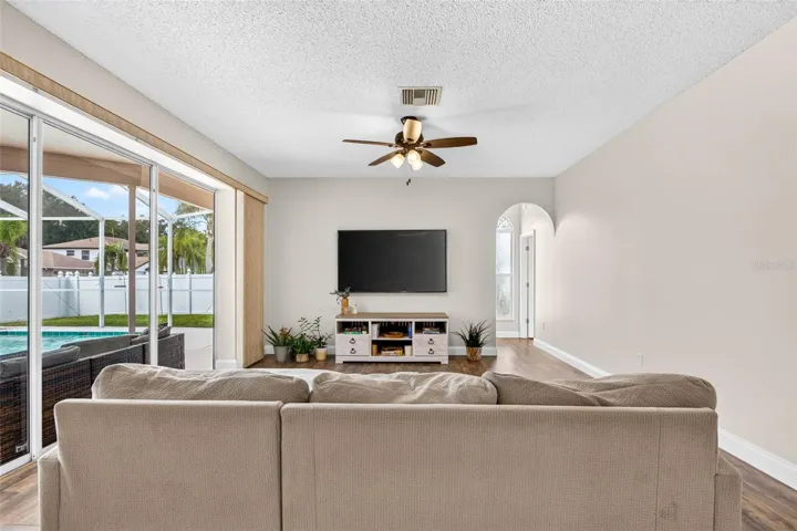 Large family room adjacent to kitchen with views of screened pool lanai