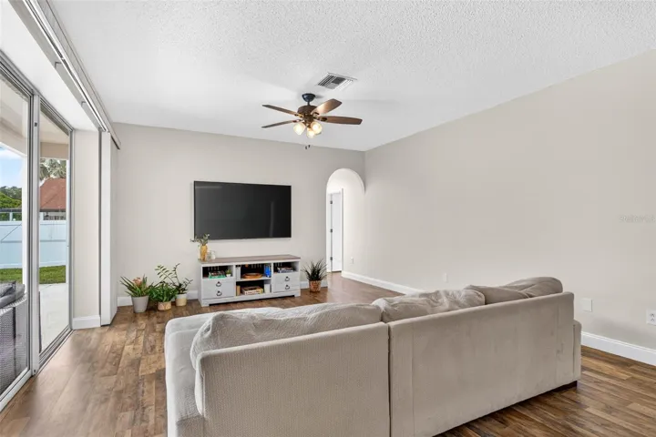 Large family room adjacent to kitchen with views of screened pool lanai