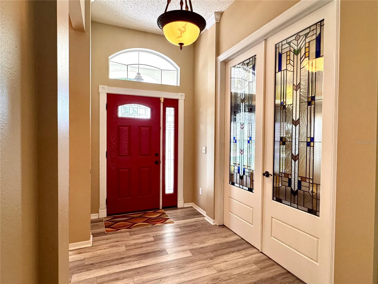 Entry foyer with decorative glass double doors leading to the private office