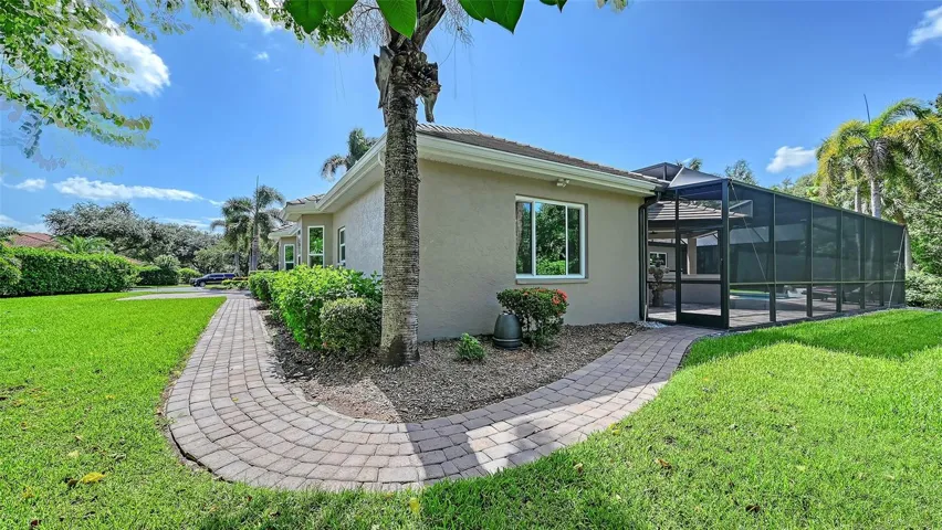 The right side of the home with paver walkway from the front to the pool area.