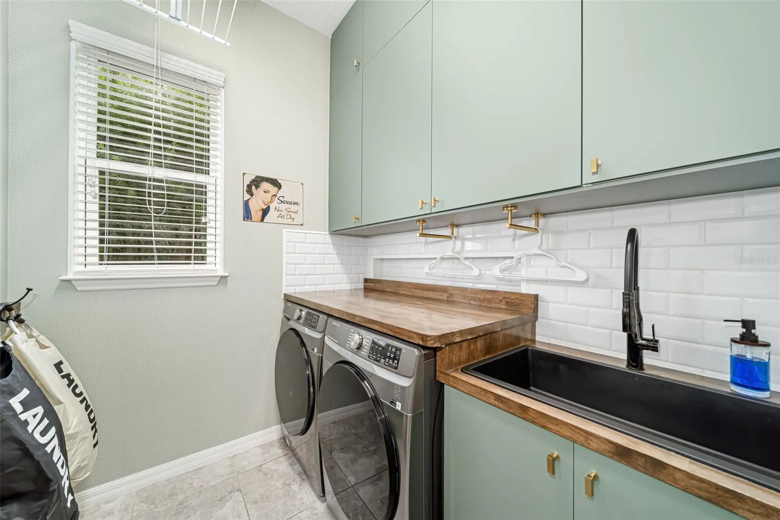 Thoughtfully designed laundry room with a utility sink and custom folding racks.