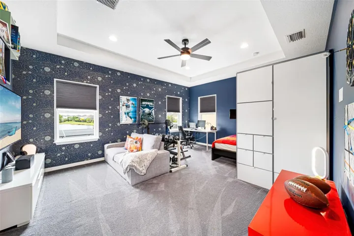 Spacious oversized bedroom showcasing custom built-in shelving and picturesque lake views.
