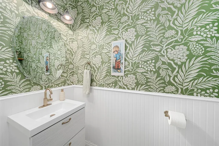 Guest bathroom enhanced by stylish wallpaper and a touch of personality.