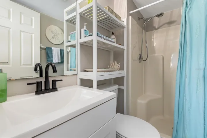 PRIMARY WALK IN SHOWER SOLID SURFACE COUNTER.