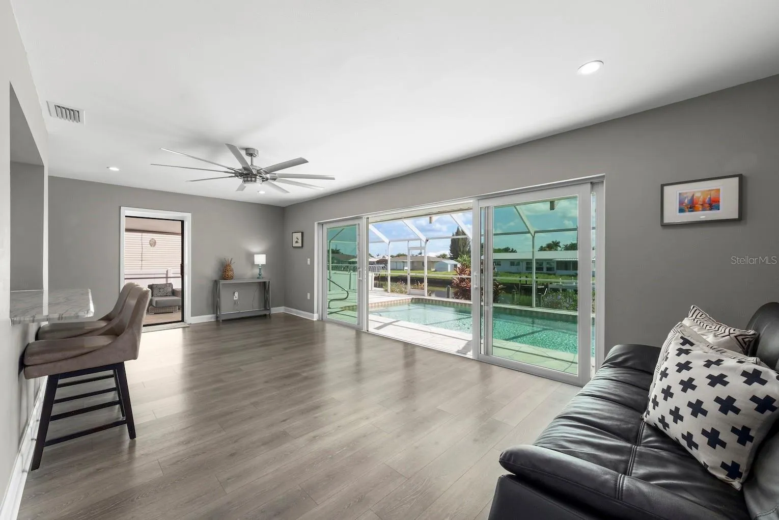 Kitchen overlooking gathering space that leads to multiple sliders to lanai space cont.