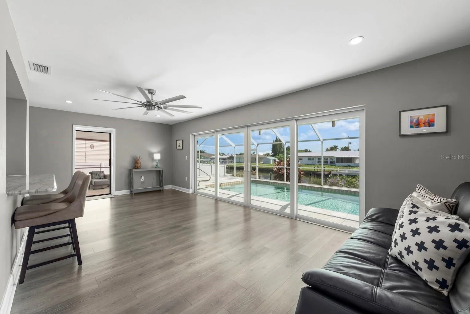 Kitchen overlooking gathering space that leads to multiple sliders to lanai space.