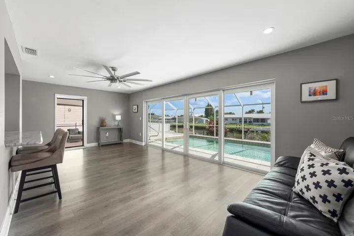 Kitchen overlooking gathering space that leads to multiple sliders to lanai space.