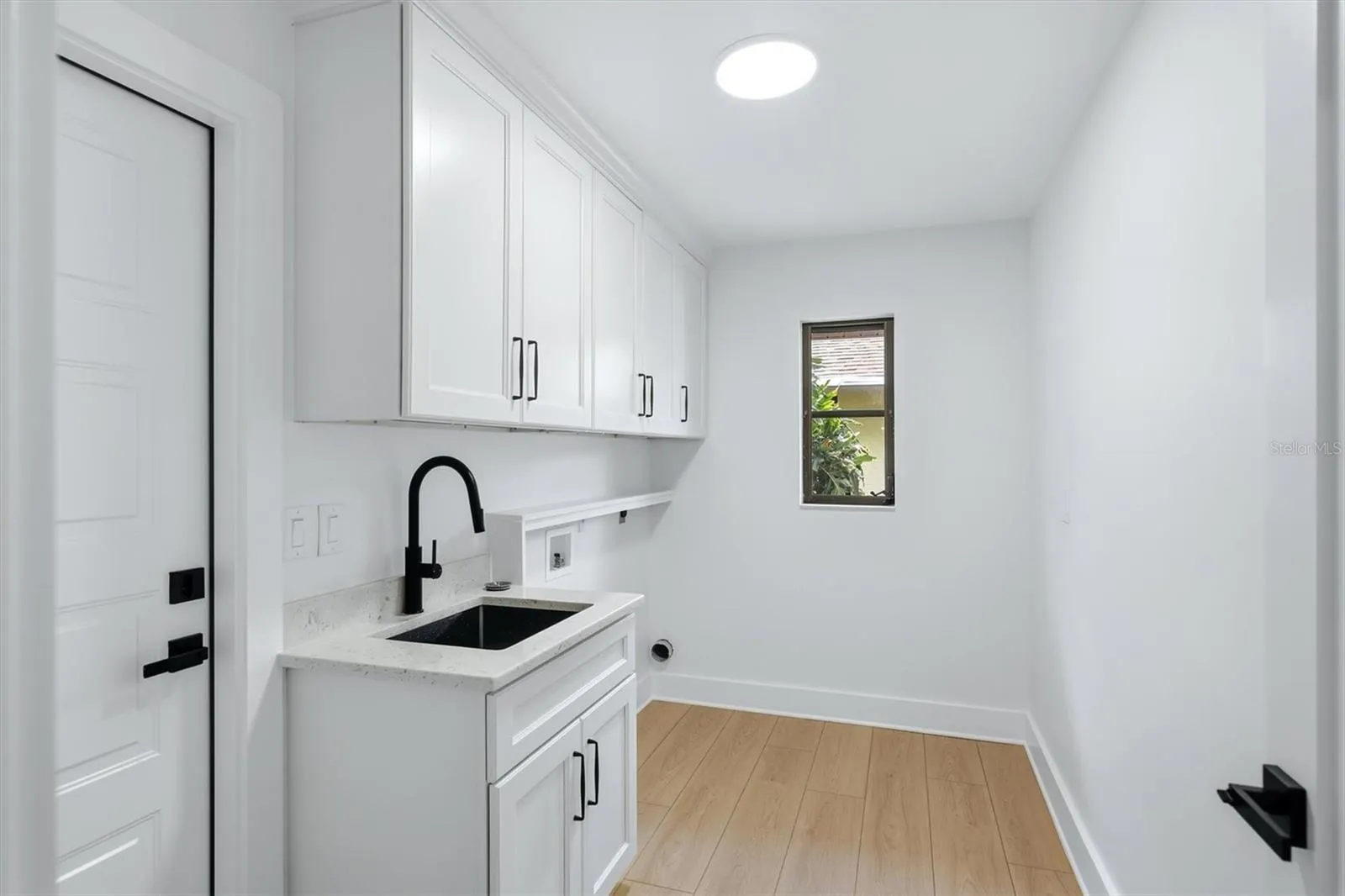Large Laundry room with utility sink, cabinets and a window!