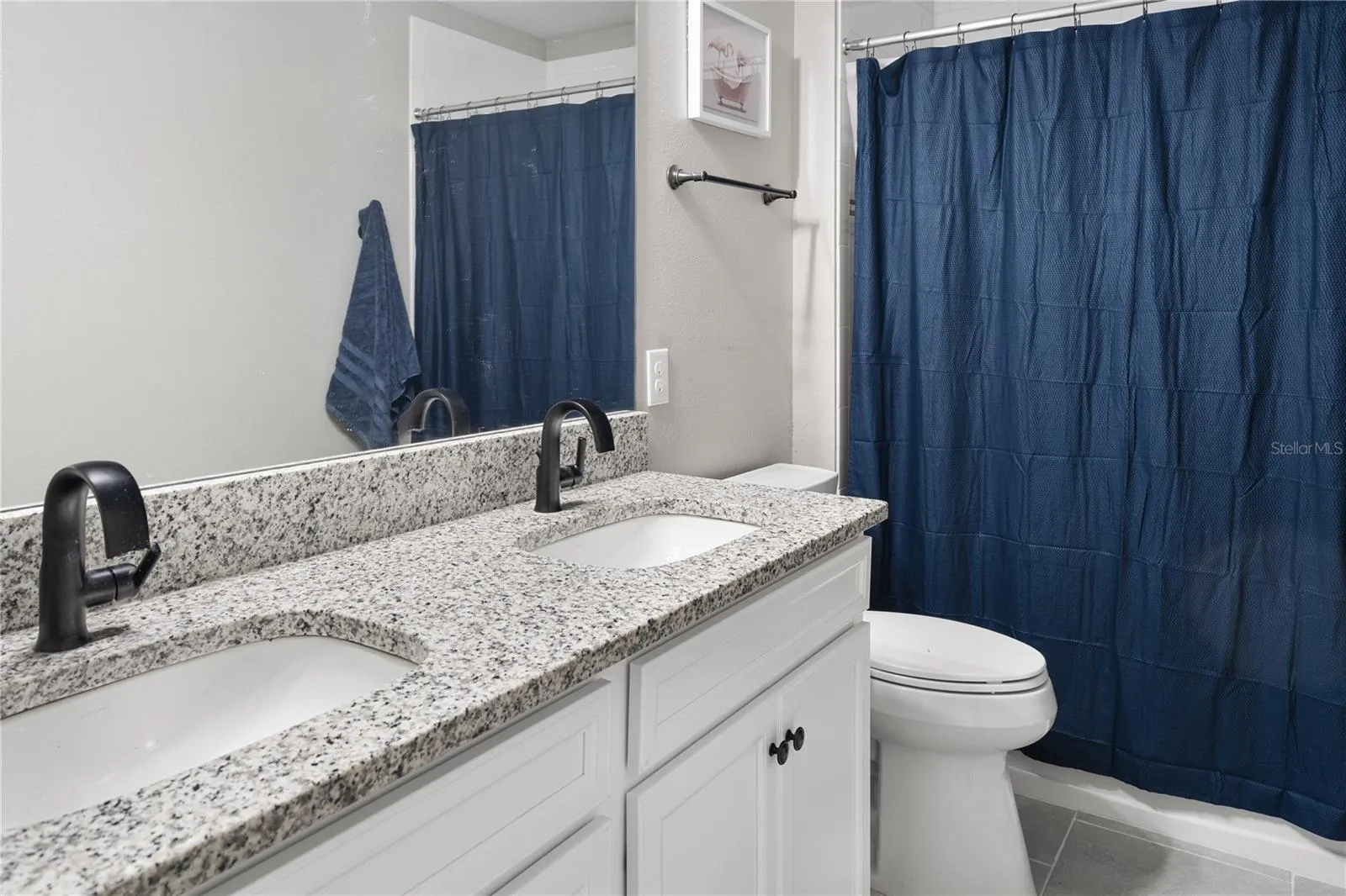 Dual undermount sinks in granite counters in the upstairs hall bath