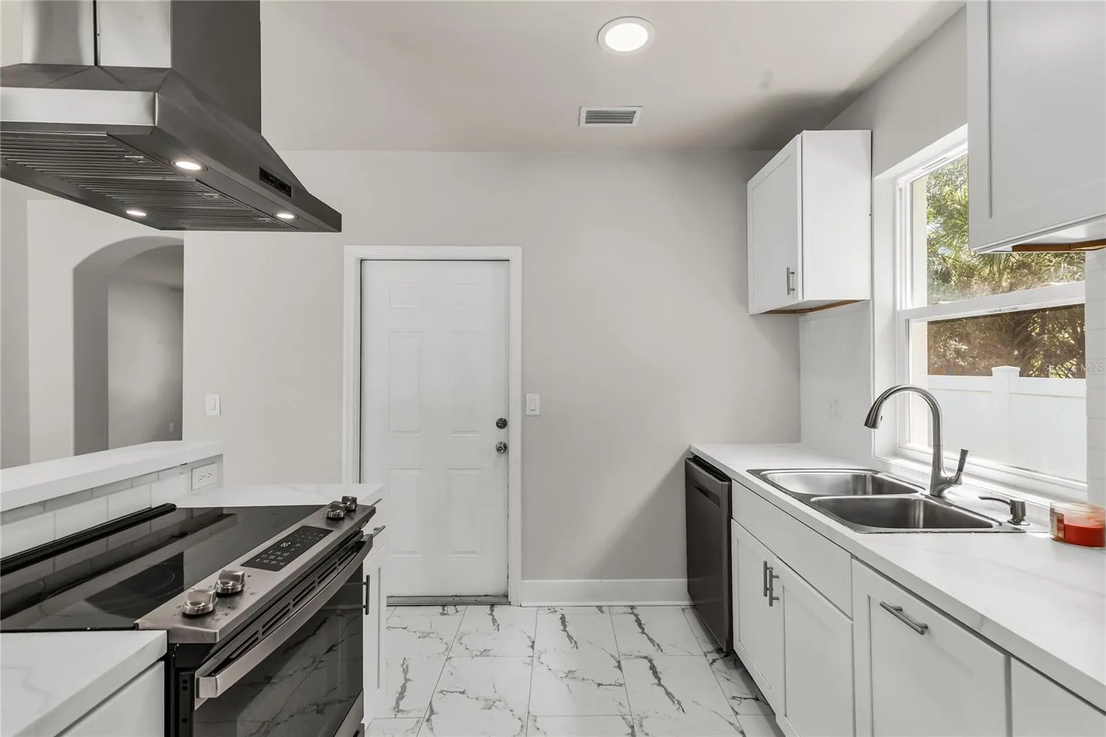 Kitchen features granite countertops, modern subway tile backsplash and stainless steel appliances.